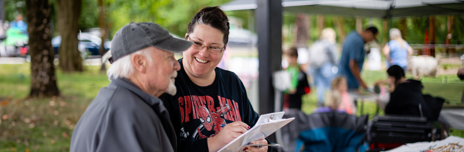 Columbia Pacific representative chats with community member at a story-collection event.